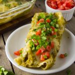 This chicken enchiladas with roasted green chile sauce recipe is a delicious dinner option when you're craving Southwestern style comfort food. The mellow spicy flavor of the Anaheim or New Mexico type peppers pairs well with shredded chicken and Mexican spices and cheese.